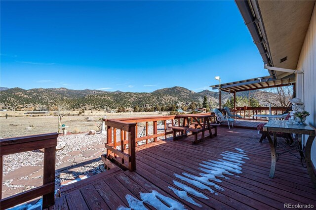 wooden deck with a mountain view and a pergola