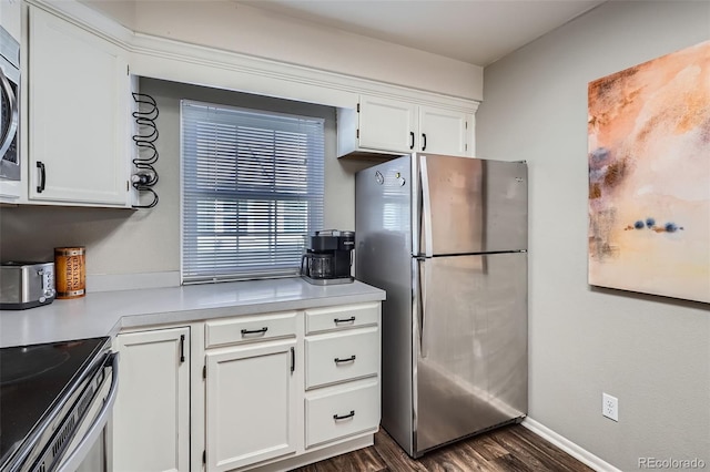 kitchen with stainless steel appliances, dark wood-style flooring, white cabinetry, and light countertops