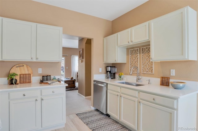 kitchen with arched walkways, stainless steel dishwasher, a sink, light countertops, and white cabinetry