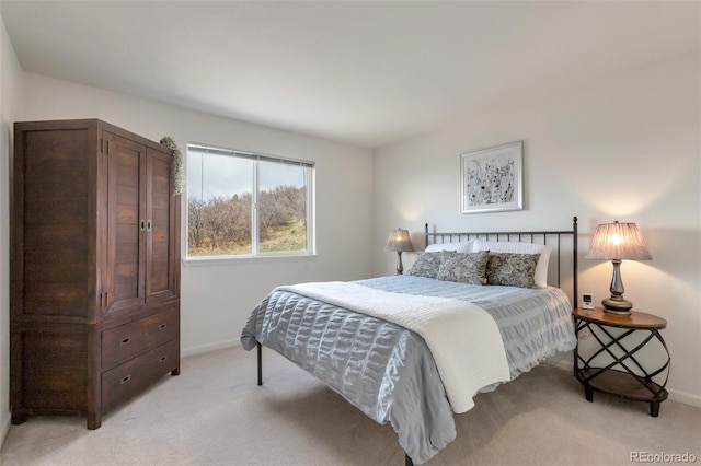 bedroom featuring light colored carpet and baseboards