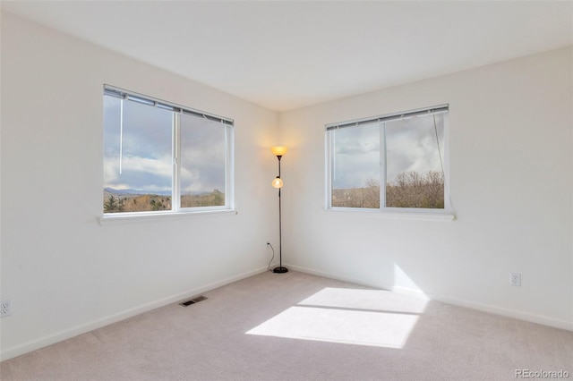 unfurnished room with baseboards, carpet flooring, and visible vents