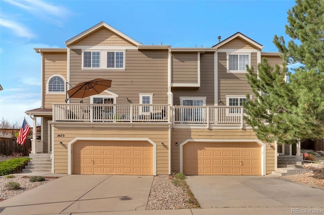 view of property with concrete driveway, a balcony, and a garage
