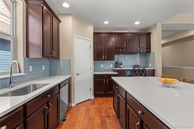 8272 E 55th Pl, Denver, CO 80238 - kitchen with stainless steel dishwasher, light wood finished floors, light countertops, dark brown cabinetry, and recessed lighting