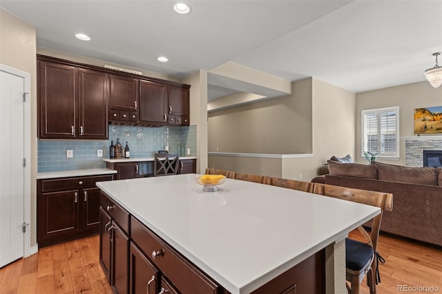 8272 E 55th Pl, Denver, CO 80238 - kitchen featuring light wood-style flooring, open floor plan, light countertops, decorative backsplash, and recessed lighting