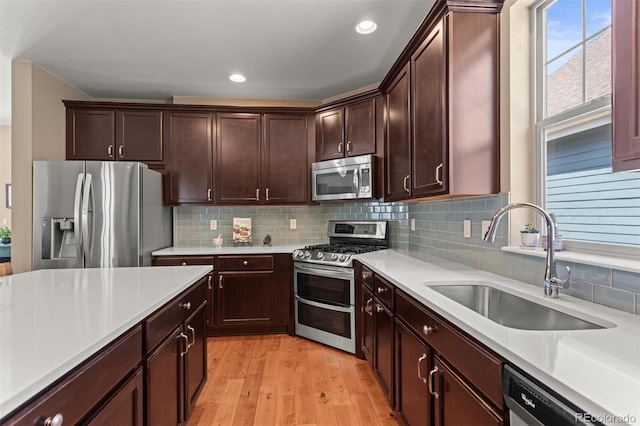 8272 E 55th Pl, Denver, CO 80238 - kitchen featuring appliances with stainless steel finishes, light wood-style floors, light countertops, decorative backsplash, and dark brown cabinetry