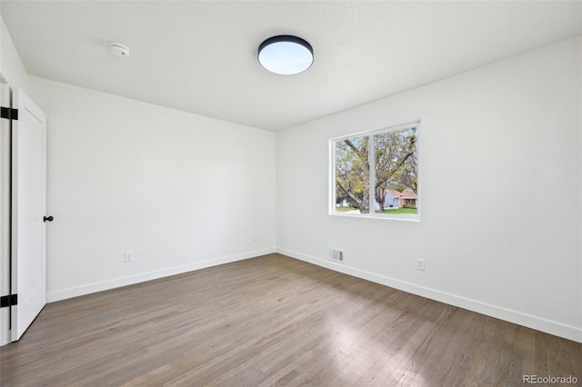 unfurnished bedroom with baseboards, visible vents, and wood finished floors