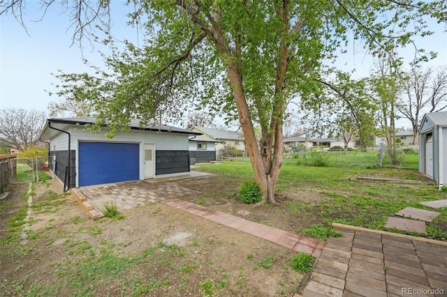 view of yard featuring a garage and fence