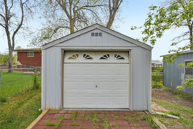 detached garage featuring a shed and fence