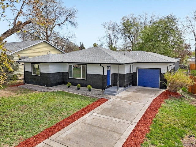 view of front of house with an attached garage, a shingled roof, a front lawn, and concrete driveway