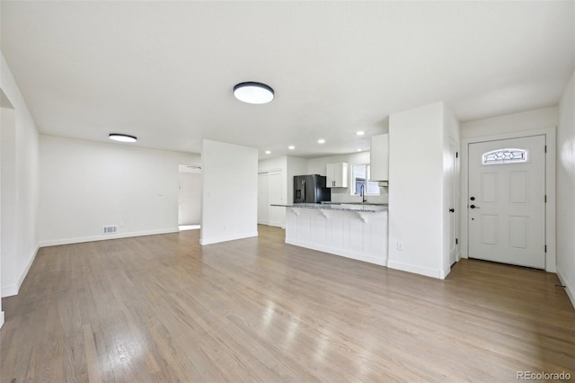 7780 Osceola St, Westminster, CO 80030 - unfurnished living room featuring light wood-style floors and recessed lighting