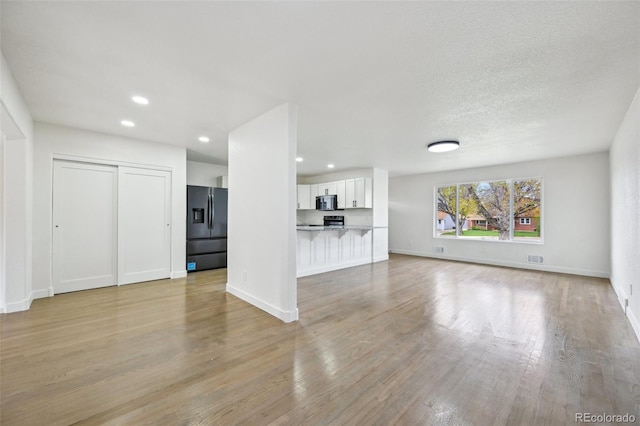 7780 Osceola St, Westminster, CO 80030 - unfurnished living room featuring light wood-style floors and recessed lighting