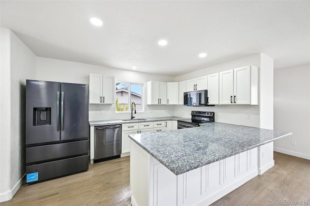 7780 Osceola St, Westminster, CO 80030 - kitchen with appliances with stainless steel finishes, a peninsula, light wood-style flooring, white cabinets, and recessed lighting