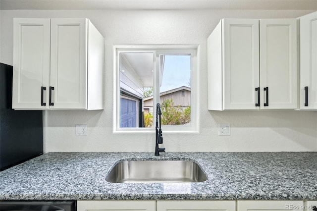 7780 Osceola St, Westminster, CO 80030 - kitchen featuring white cabinetry, stone counters, and a textured wall