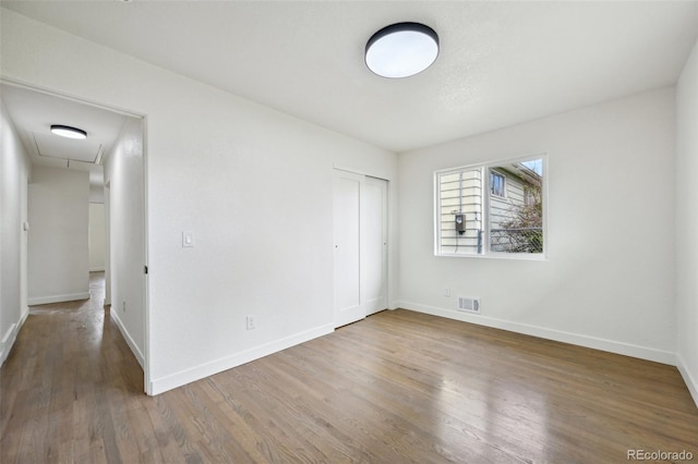 7780 Osceola St, Westminster, CO 80030 - unfurnished bedroom featuring attic access, wood finished floors, and a closet
