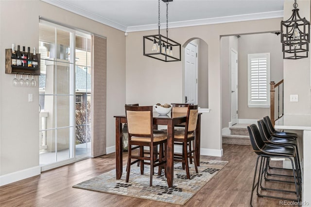 dining space featuring ornamental molding and dark hardwood / wood-style flooring