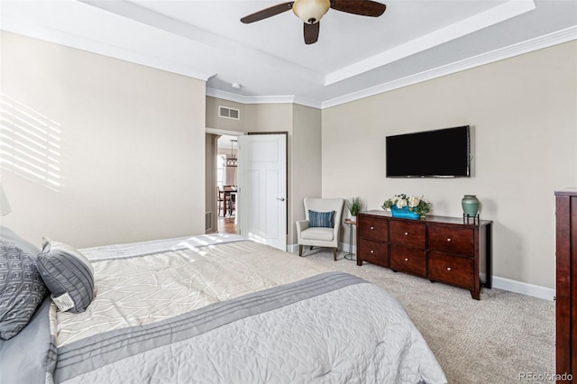 bedroom with a raised ceiling, crown molding, light colored carpet, and ceiling fan