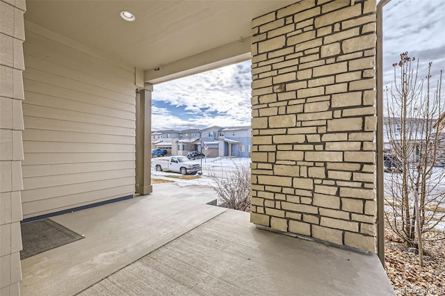 snow covered patio with a residential view