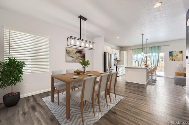 dining area with recessed lighting, dark wood-style flooring, a textured ceiling, and baseboards