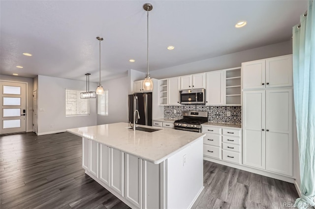 kitchen featuring open shelves, appliances with stainless steel finishes, a kitchen island with sink, a sink, and white cabinetry