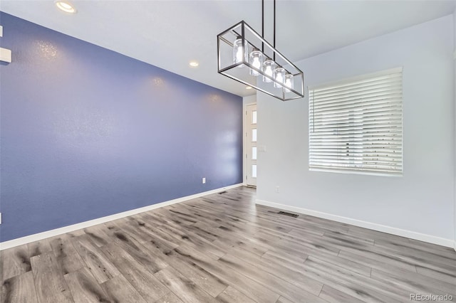 unfurnished dining area featuring visible vents, baseboards, wood finished floors, and recessed lighting