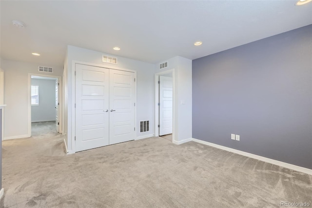 unfurnished bedroom featuring visible vents, carpet flooring, and baseboards