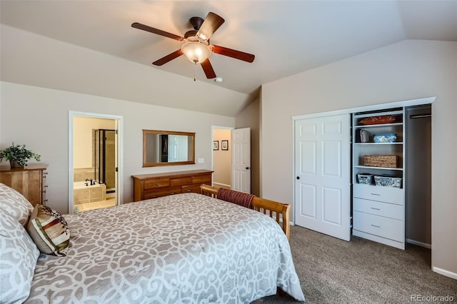 carpeted bedroom featuring a closet, ensuite bath, a ceiling fan, and vaulted ceiling