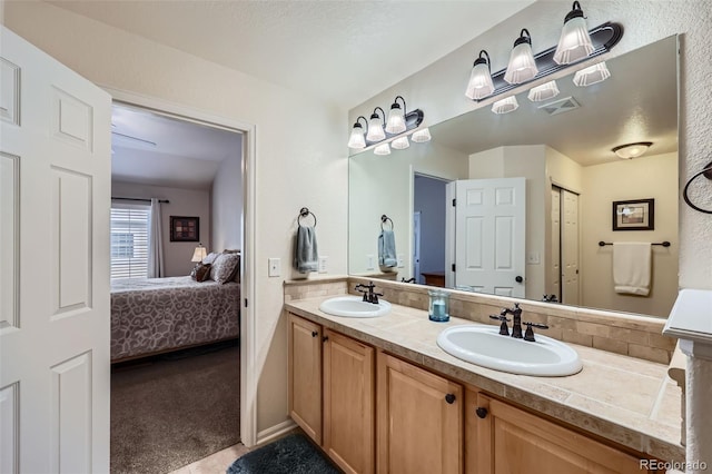 ensuite bathroom featuring a sink, visible vents, double vanity, and ensuite bath