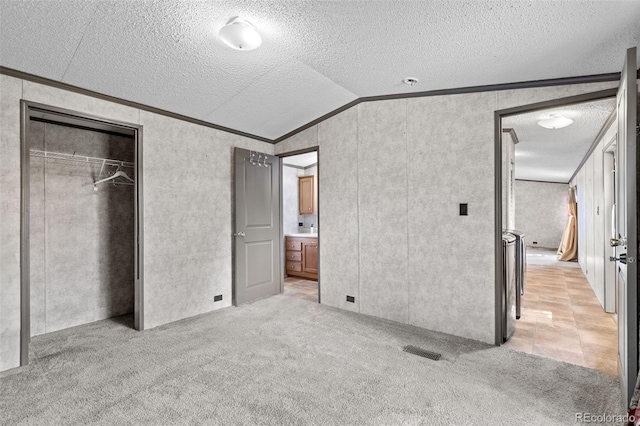 715 E Chester St, Lafayette, CO 80026 - unfurnished bedroom featuring ornamental molding, vaulted ceiling, light carpet, a textured ceiling, and a closet
