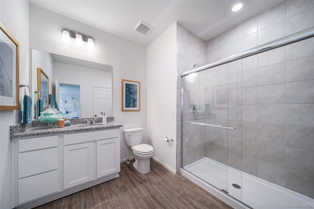 bathroom featuring an enclosed shower, vanity, toilet, and hardwood / wood-style flooring