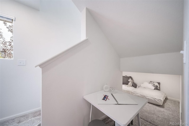 carpeted home office featuring vaulted ceiling