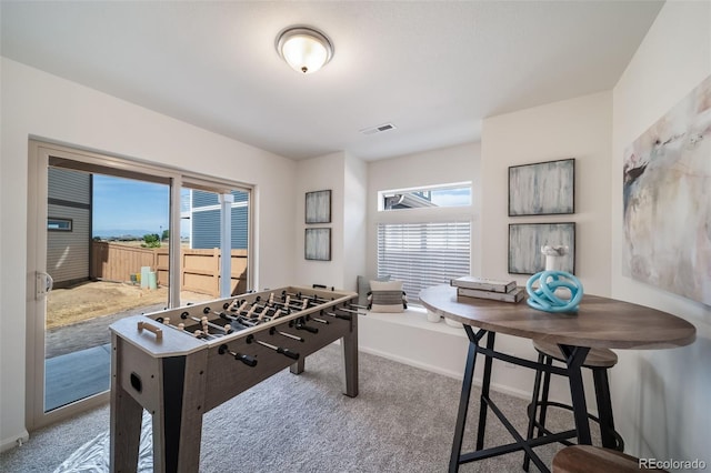 recreation room with a wealth of natural light and carpet flooring