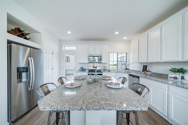 kitchen with a breakfast bar, white cabinetry, appliances with stainless steel finishes, and a kitchen island