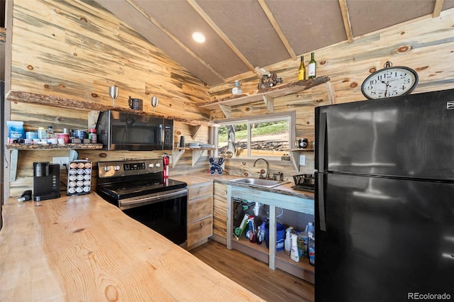 161 Highland Cir, Rye, CO 81069 - kitchen with freestanding refrigerator, stainless steel range with electric stovetop, a sink, vaulted ceiling, and wood finished floors
