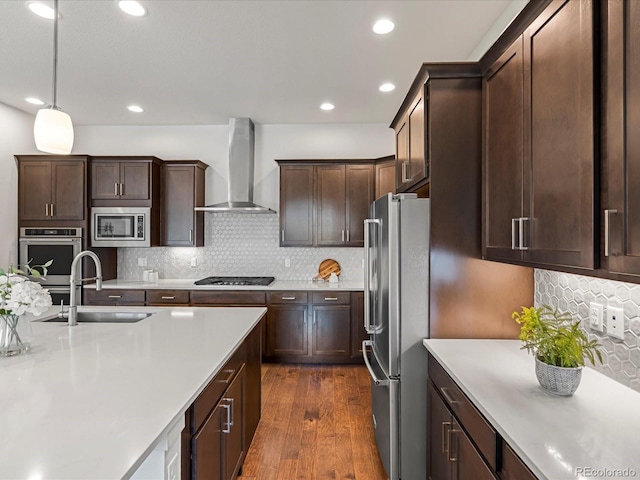 10235 E 59th Ave, Denver, CO 80238 - kitchen with stainless steel appliances, wall chimney range hood, light countertops, dark wood-style flooring, and recessed lighting