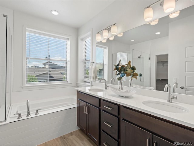10235 E 59th Ave, Denver, CO 80238 - bathroom featuring a stall shower, a spacious closet, double vanity, a garden tub, and wood finished floors