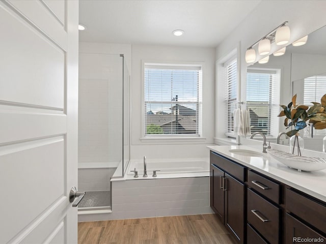 10235 E 59th Ave, Denver, CO 80238 - full bathroom with a garden tub, double vanity, a shower stall, wood finished floors, and recessed lighting