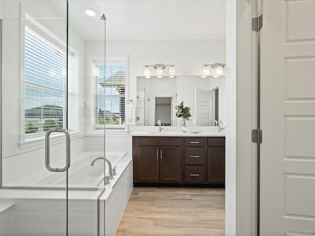 10235 E 59th Ave, Denver, CO 80238 - bathroom with double vanity, a garden tub, and wood finished floors