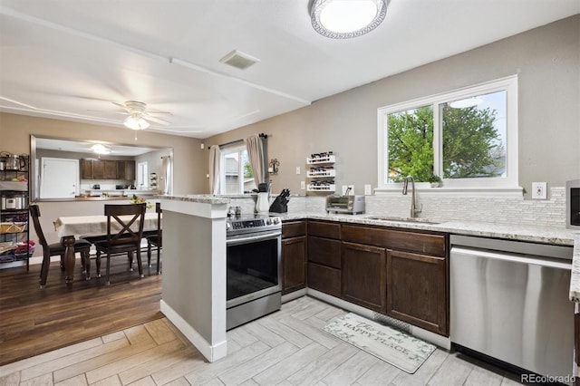 21125 E 43rd Ave, Denver, CO 80249 - kitchen featuring stainless steel appliances, a sink, a peninsula, and healthy amount of natural light