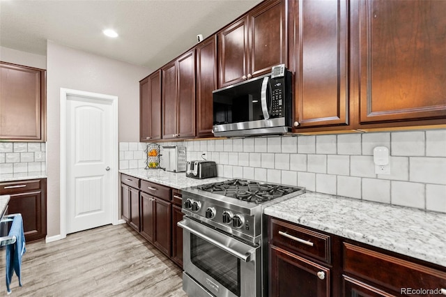 7018 E 123rd Pl, Thornton, CO 80602 - kitchen with appliances with stainless steel finishes, light stone countertops, light wood finished floors, decorative backsplash, and recessed lighting