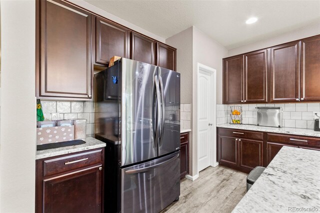 7018 E 123rd Pl, Thornton, CO 80602 - kitchen featuring stainless steel fridge with ice dispenser, light wood-style flooring, backsplash, and dark brown cabinets