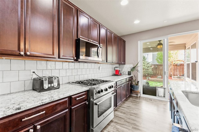 7018 E 123rd Pl, Thornton, CO 80602 - kitchen featuring stainless steel appliances, light wood-type flooring, light stone counters, decorative backsplash, and recessed lighting