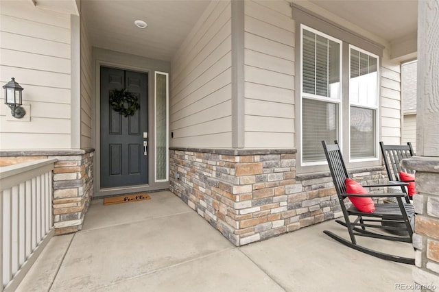 property entrance with stone siding and covered porch
