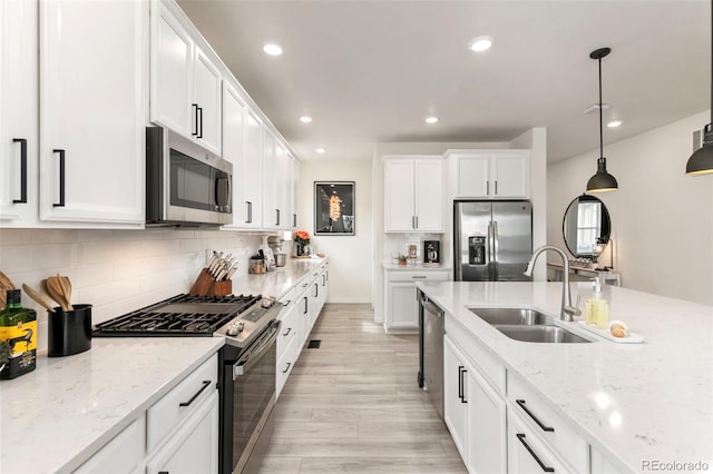 kitchen featuring recessed lighting, white cabinets, a sink, and stainless steel appliances