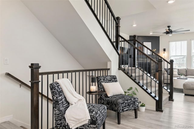 stairs with baseboards, wood finished floors, ceiling fan, and recessed lighting