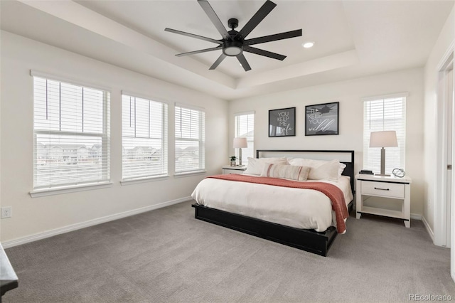 carpeted bedroom with a ceiling fan, a tray ceiling, baseboards, and recessed lighting