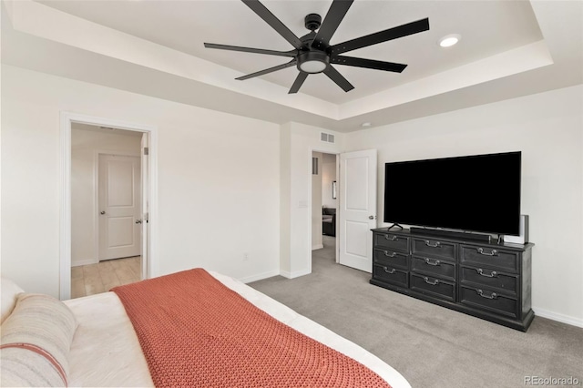 bedroom featuring baseboards, visible vents, and a raised ceiling