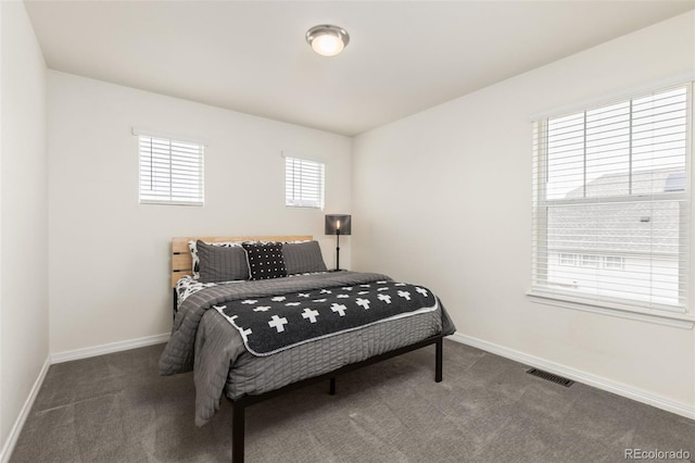 carpeted bedroom featuring baseboards and visible vents