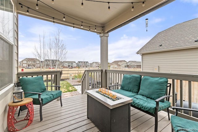 wooden terrace with a fire pit and a residential view