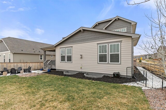 rear view of property featuring a fenced backyard, a yard, and a patio
