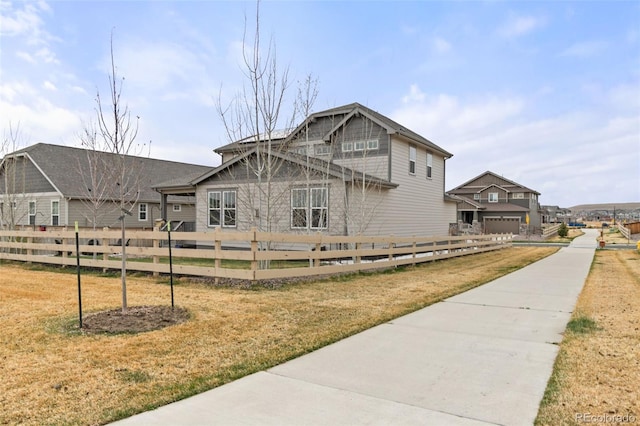 view of side of property featuring a lawn and fence